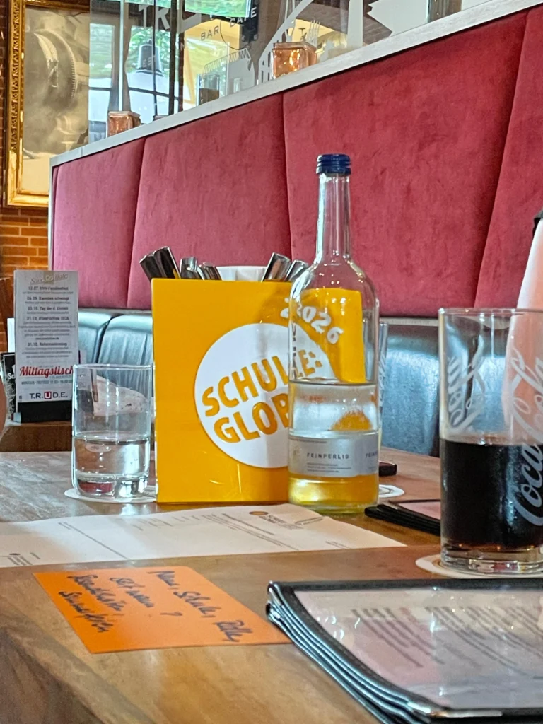 Tischdekoration mit Getränken und Menüs in einem modernen Restaurant, das Vielfalt und Geselligkeit ausstrahlt.