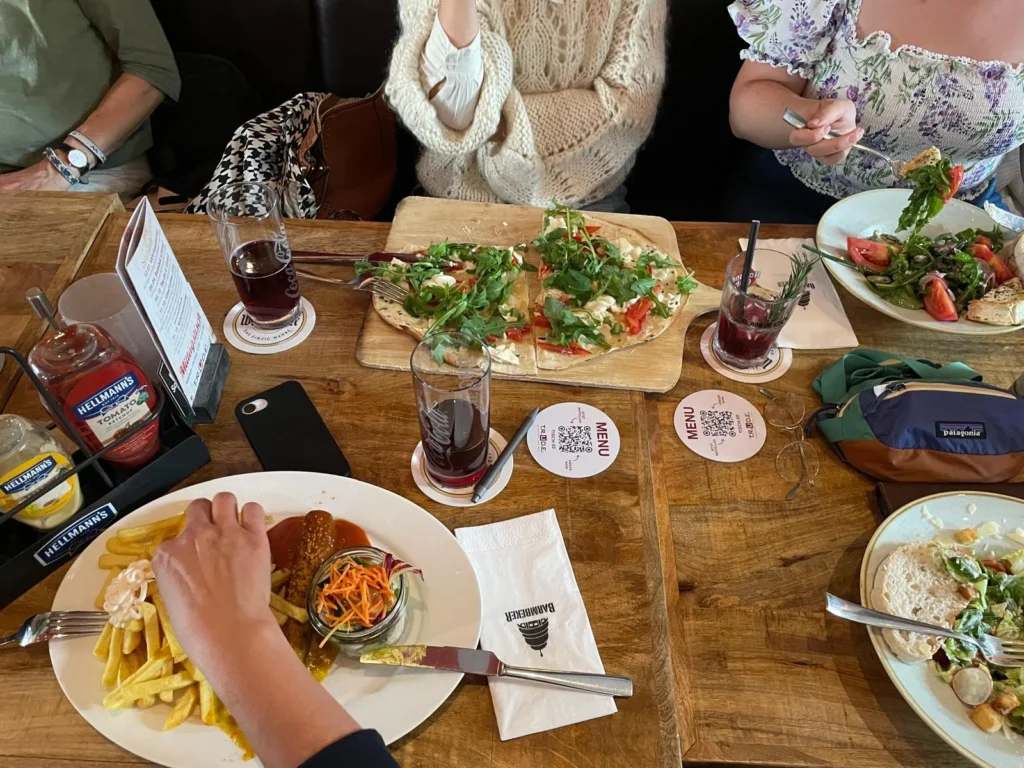 Bunt gedeckter Tisch mit verschiedenen Gerichten und Getränken, ideal für geselliges Beisammensein und kulinarische Vielfalt.